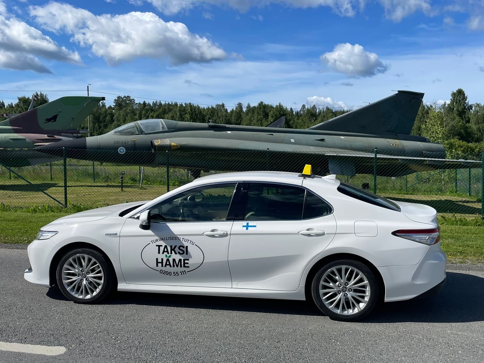 Valkoinen Toyota Camry Hybrid -taksi