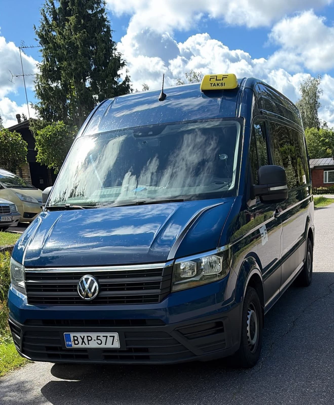 Blue accessible Volkswagen Crafter minibus taxi with an FLF Taksi sign